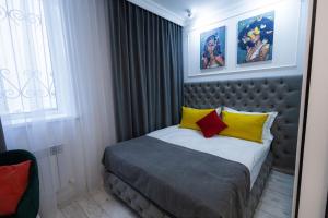卡拉甘达Metelitsa Hotel的一间卧室配有黄色和红色枕头的床