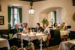 圣吉尔根Hotel Gasthof zur Post的一群坐在餐厅桌子上的人