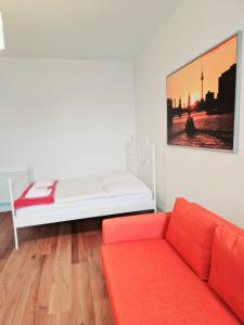 柏林City Studio Apartment for 4, near Sonnenallee的一张白色的床,在房间内配有红色沙发
