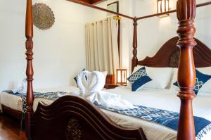 琅勃拉邦Villa Khili Namkhan的一间卧室配有两张带蓝白色枕头的床