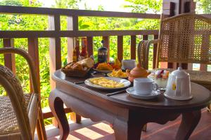 琅勃拉邦Villa Khili Namkhan的门廊上的餐桌,包括早餐食品