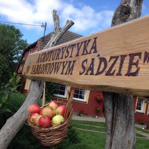 JeżyceAgroturystyka W Jabłoniowym Sadzie的房屋前有一篮苹果的标牌