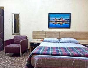 AkwaBravo Apartment, Awka的一间卧室配有一张床和一把椅子