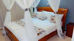 恩德培Victoria Rock Resort的一间卧室配有带白色床单和枕头的床。