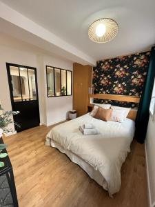 耶尔Appartement centre historique, idéal couple的一间卧室配有一张大床和花卉床头板