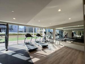 迪拜Luxe Den-1BR Cozy Treat By Canal side的带有氧器材的健身房,位于带窗户的大楼内
