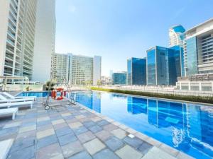 迪拜Luxe Den-1BR Cozy Treat By Canal side的一座位于高楼城市的游泳池