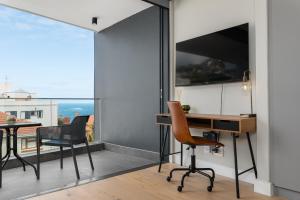 开普敦Ocean & Mountain Views From Bantry Bay Apartment的客房设有桌子、椅子和窗户。