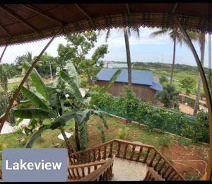 邦隆Ratanakiri Lakeside Homestay & Tours的享有带2个木凳的房子的景色