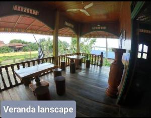 邦隆Ratanakiri Lakeside Homestay & Tours的铺有木地板的凉亭配有长椅和桌子