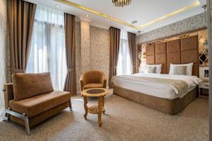 第比利斯Hotel Aqua Liberty的配有一张床和一把椅子的酒店客房