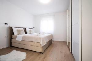 比比涅Apartmani Carmen的白色的卧室设有床和窗户