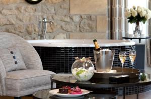 MontenachDomaine de la Klauss & Spa, Restaurant Gastronomique Le K的一间提供一瓶香槟和一张酒杯桌子的房间