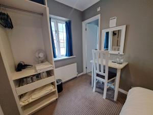 格洛斯特The Thatch Inn的小房间设有床、书桌和镜子