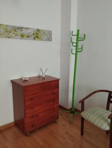 韦斯卡Acogedor Apartamento En Huesca的一间设有梳妆台、椅子和绿杆的房间