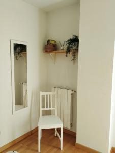 韦斯卡Acogedor Apartamento En Huesca的一张白色椅子,坐在带镜子的房间