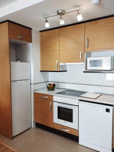 韦斯卡Acogedor Apartamento En Huesca的厨房配有白色家电和木制橱柜