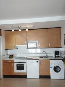 韦斯卡Acogedor Apartamento En Huesca的厨房配有白色家电和木制橱柜