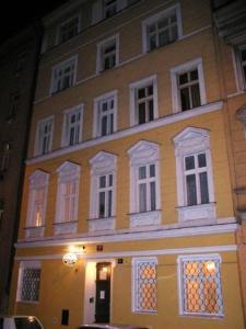 布拉格布拉格市佩西恩酒店的一条黄色的大建筑,在街上有白色的窗户