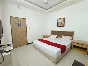 普杰Usha Residency的一间卧室配有一张床和一部电话