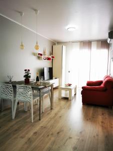 罗列特海岸Apartment Ruby的客厅配有桌子和红色沙发