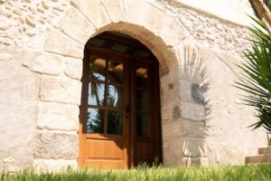 MedionaCan Óscar Rural Casa con piscina y barbacoa ideal para famílias的石头建筑中一扇门,有窗户