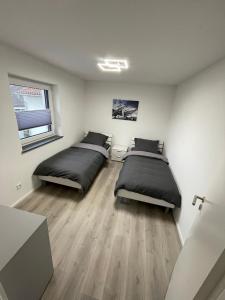 菲尔德施塔特Moderne Apartments in zentraler Lage的小型客房铺有木地板,配有两张床。