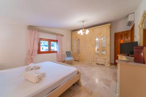 奥尔比亚Brorent Domo de Aurora的卧室配有白色的床和电视