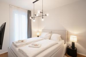 维也纳Vienna Heights Premium Apartments的白色卧室配有一张白色大床和2条白色毛巾