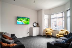 曼彻斯特England's Cozy 1-Bed room Room 1的带沙发的客厅和墙上的电视