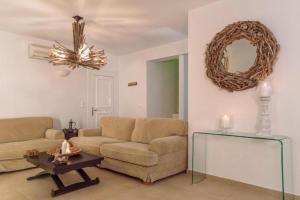 拉卡尼亚Villa Sevil的带沙发、桌子和镜子的客厅