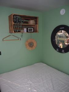 羊角村Bed-on-a-Boat的一间卧室设有一张床和一个圆形的窗户。