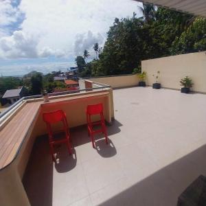 宿务Eli's Villa Cebu的两把红色椅子坐在建筑物的屋顶上