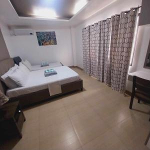 宿务Eli's Villa Cebu的一间卧室,卧室内配有床和窗帘