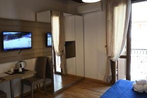 阿尔盖罗Double B Maison De Charme的一间带镜子、一张桌子和一台电视的卧室