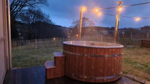 拉罗什-阿登Ardennature vakantiehuizen met privé-sauna的夜间在院子里的木制热水浴缸