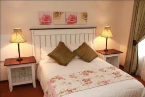 德尔斯特鲁姆The Rose Cottage B&B的一间卧室配有一张带两张台灯的床铺。