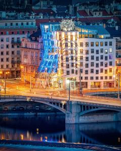 布拉格Dancing House - Tančící dům hotel的享有夜间城市美景,设有一座建筑