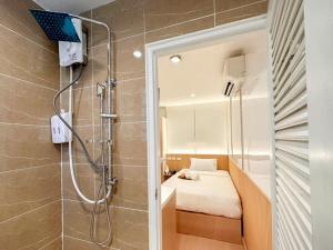 曼谷Thrive Hotel的带淋浴、床和镜子的浴室