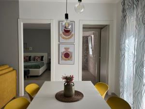 马扎拉德尔瓦洛Volturno3 Suites & more的一间设有白色桌子和黄色椅子的用餐室