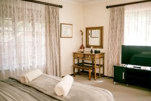 诺丁汉路Thatchings Guest House的一间卧室配有一张床、一台电视和一张桌子