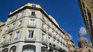 萨拉戈萨Apartamentos Almada的带阳台和圆顶的高高的白色建筑