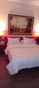 都拉斯德睿尼酒店的两张位于酒店客房的床,墙上挂着一幅画