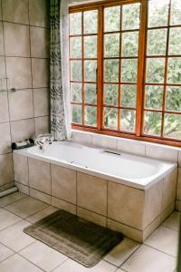 诺丁汉路Thatchings Guest House的带浴缸的浴室和窗户