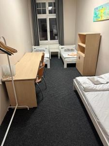 弗罗茨瓦夫Chilli Hostel的宿舍间设有床铺、书桌和桌子。
