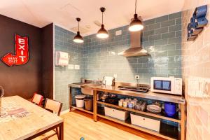 巴塞罗那Factory Hostels Barcelona的厨房配有带微波炉的柜台和桌子。
