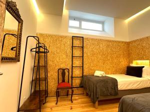 里斯本A casa na Estrela的一间卧室配有一张床、梯子和椅子