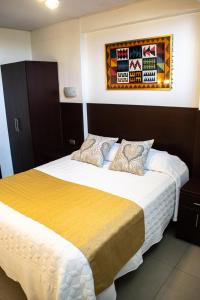 利马Hotel Hatunkay Chaclacayo的一间卧室配有一张带黄色毯子的大床