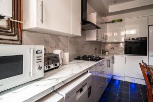 曼彻斯特Refined Comforts for Two Room 5的厨房配有白色大理石台面和白色家电