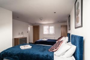 曼彻斯特Refined Comforts for Two Room 5的一间卧室配有两张床和蓝色毯子